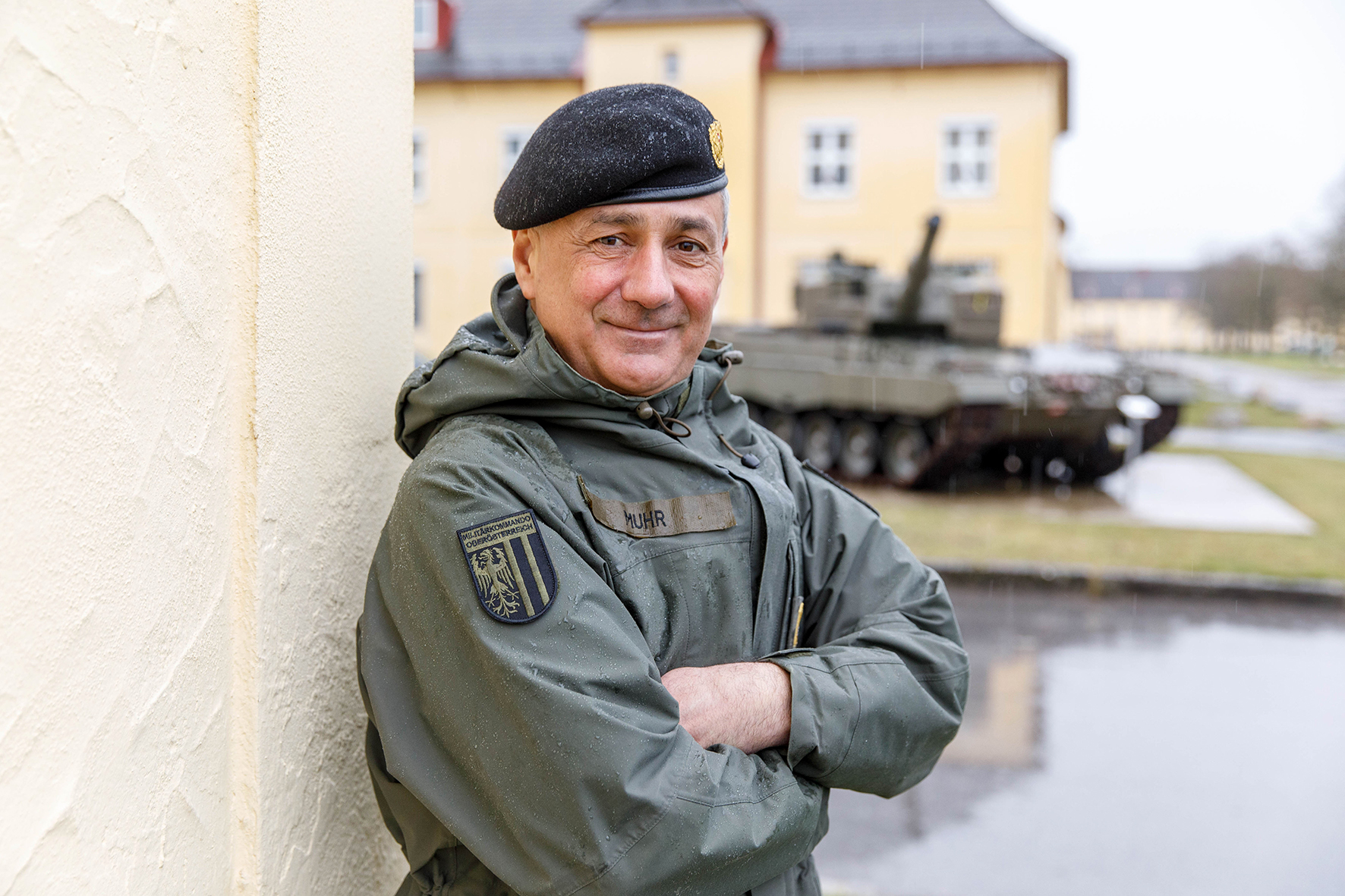 Brigadier Dieter Muhr an einer Hausmauer lehnend