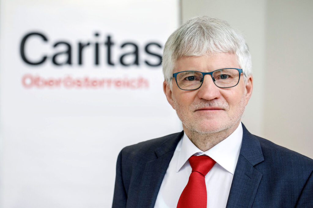 Franz Kehrer vor Caritas Logo