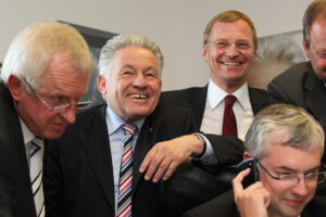 Josef Pühringer und Kollegen lachend im Büro