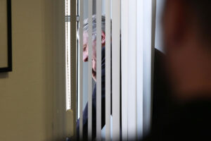 Josef Pühringer am Telefon vor einem Fenster in seinem Büro