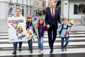 LH Thomas Stelzer auf einem Zebrastreifen mit Schulkinder