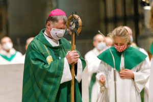 Bischof Manfred Scheuer während einer Messe mit Corona Maske und Stab in der Hand