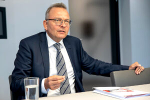 Christian Klinger in seinem Büro mit einem Wasserglas