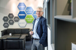 CEO Manfred Hackl an Wand lehnend in der EREMA Zentrale