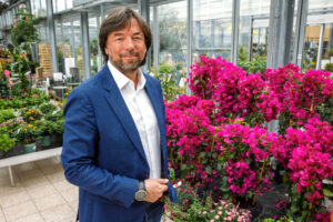 Portrait von Franz Koll vor pinken Blumen im Bellaflora Linz