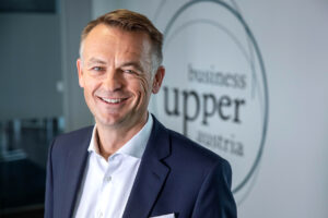 Geschäftsführer Werner Pamminger vor dem BizUp Logo