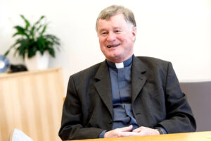 Bischof Manfred Scheuer lachend während einem Interview in seinem Büro