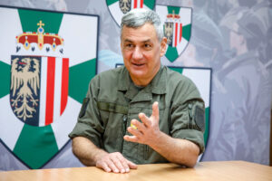 Brigadier Dieter Muhr im Interview mit Österreich Flagge im Hintergrund
