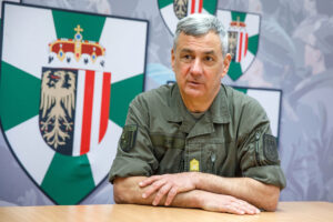 Brigadier Dieter Muhr im Interview mit Österreich Flagge im Hintergrund