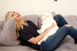 Moderatorin Nina Kraft Zuhause auf der Couch mit einer Katze