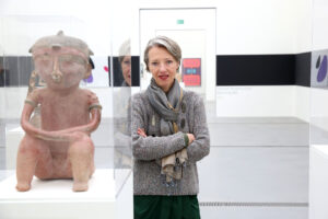 Portrait von Stella Rollig neben Kunstwerk im Lentos Linz